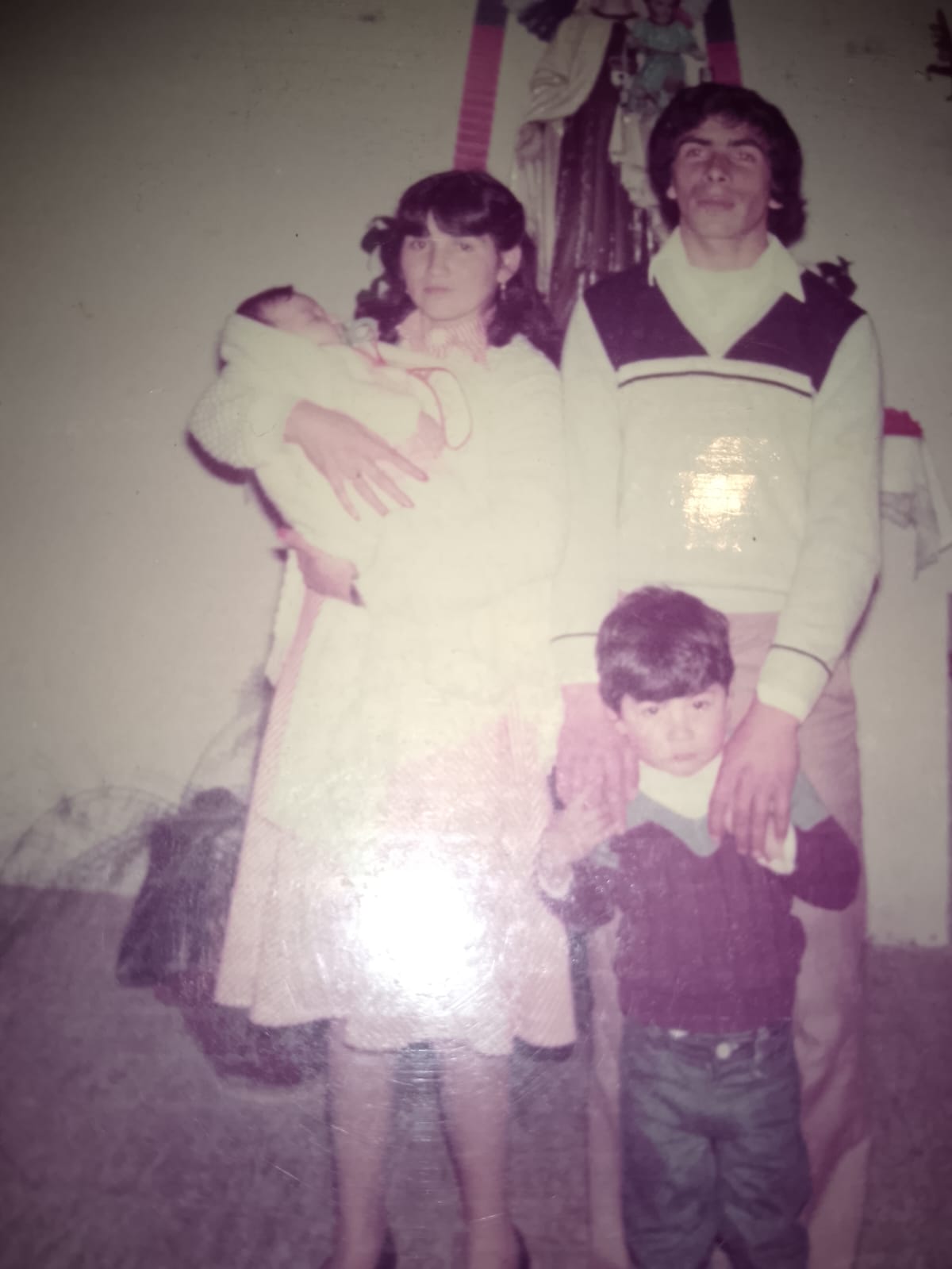 Jose Manuel as a small boy standing in front of his father, beside his mother holding a baby