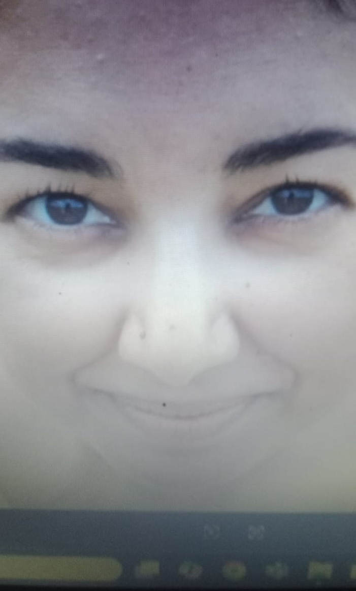 A close-up of Sabah smiling on a video call