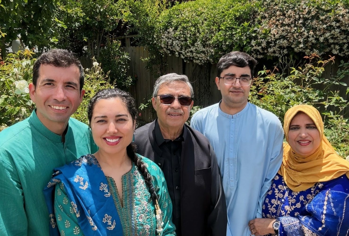 Jose Manuel and Sabah with her family in traditional Pakistani clothing in a garden