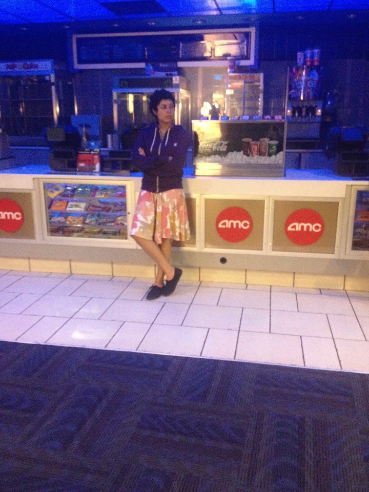 Sabah leaning against the concession counter of an AMC movie theater